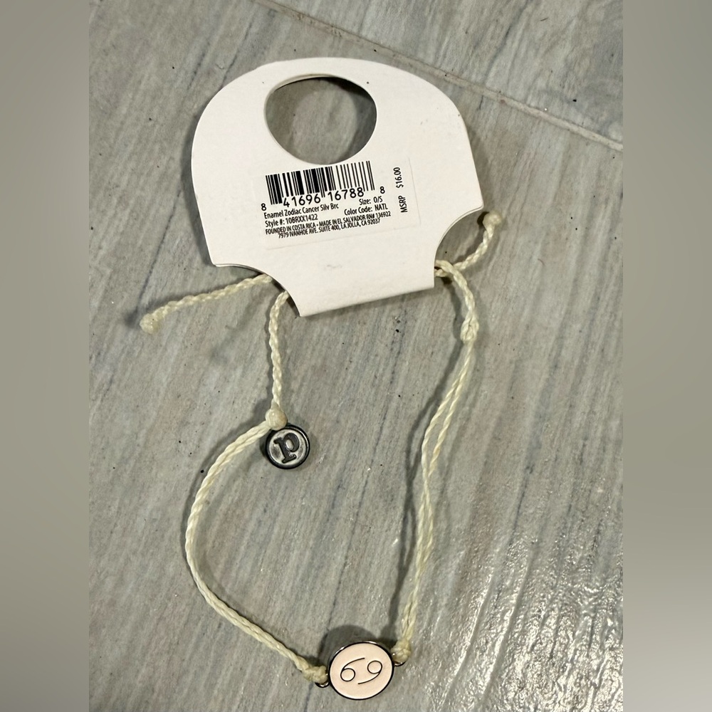 Pura Vida Cream Adjustable Bracelet with zodiac (cancer) charm.